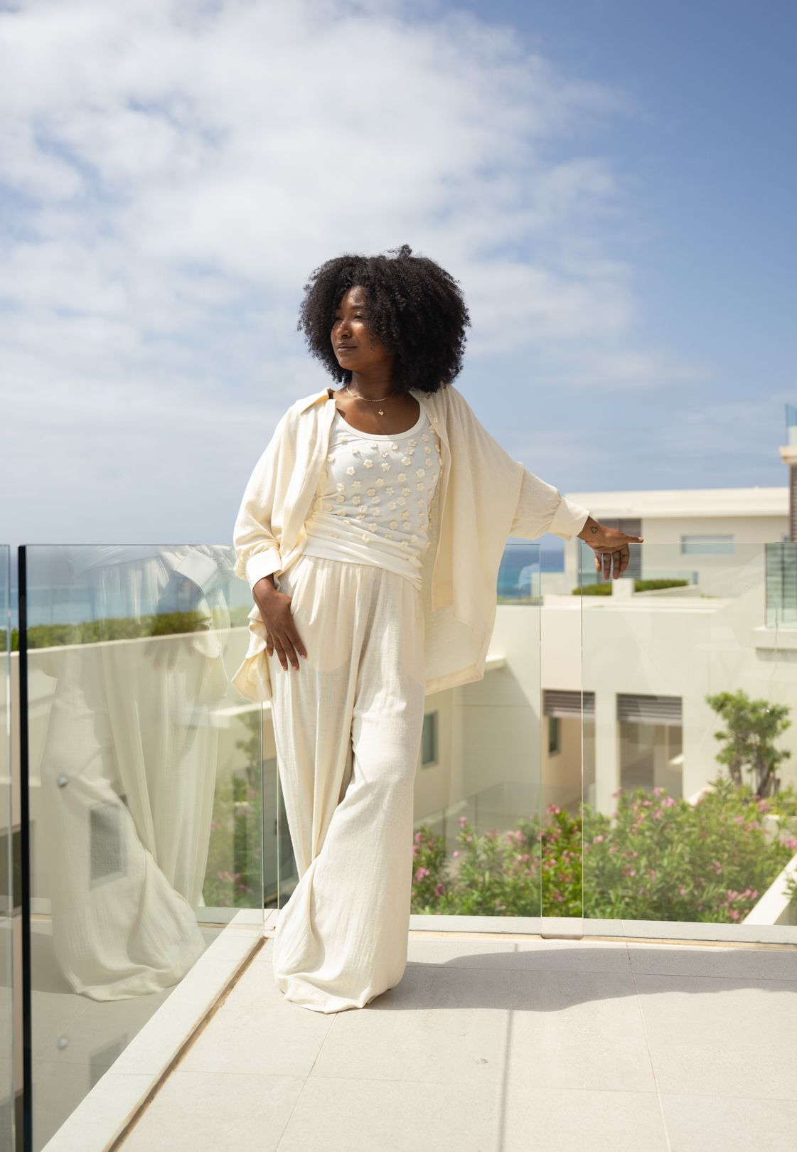 Elegant cream-colored ensemble on modern balcony overlooking coastal view.