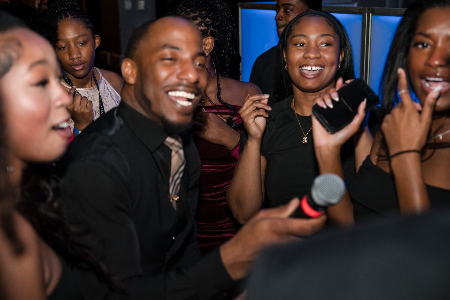 Group of people laughing and enjoying themselves at a lively formal party event.