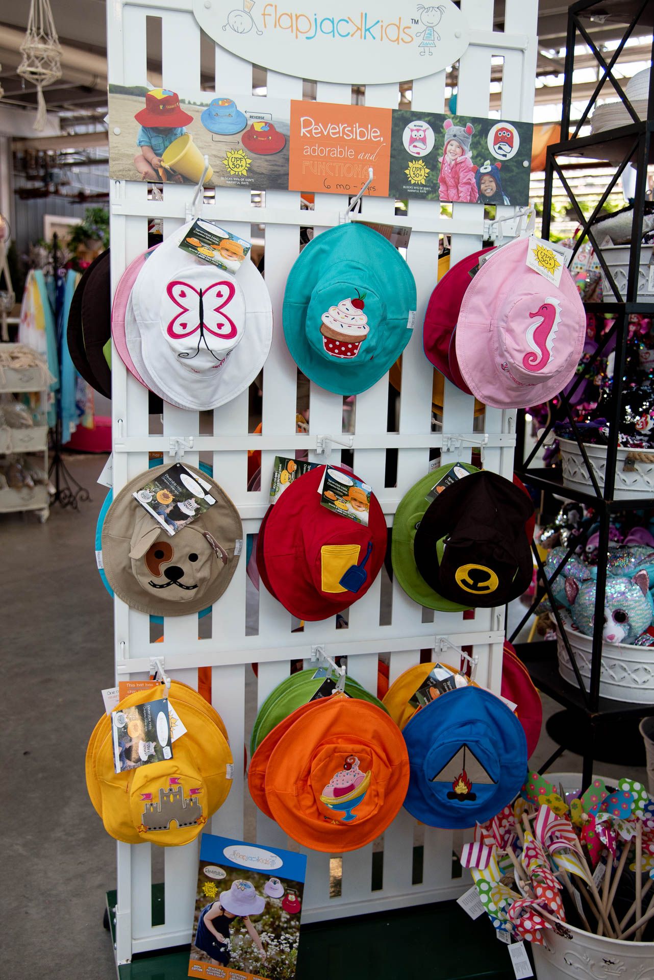 Colorful children's backpacks and bags displayed on white lattice wall rack in retail store Bradford Greenhouse in Barrie