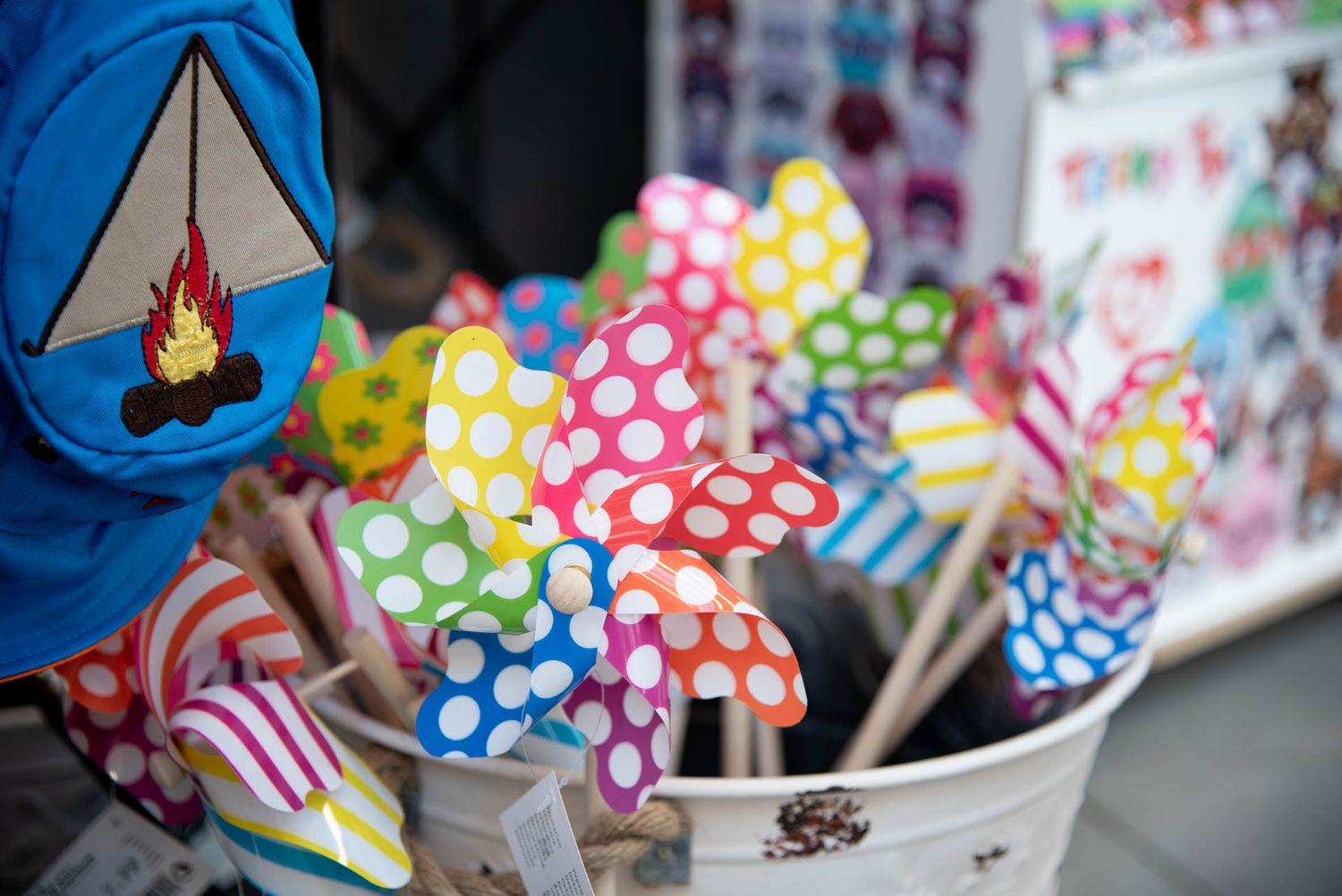 Colorful polka dot pinwheel decorations and candy canes displayed in a white container at Bradford Greenhouse in Barrie