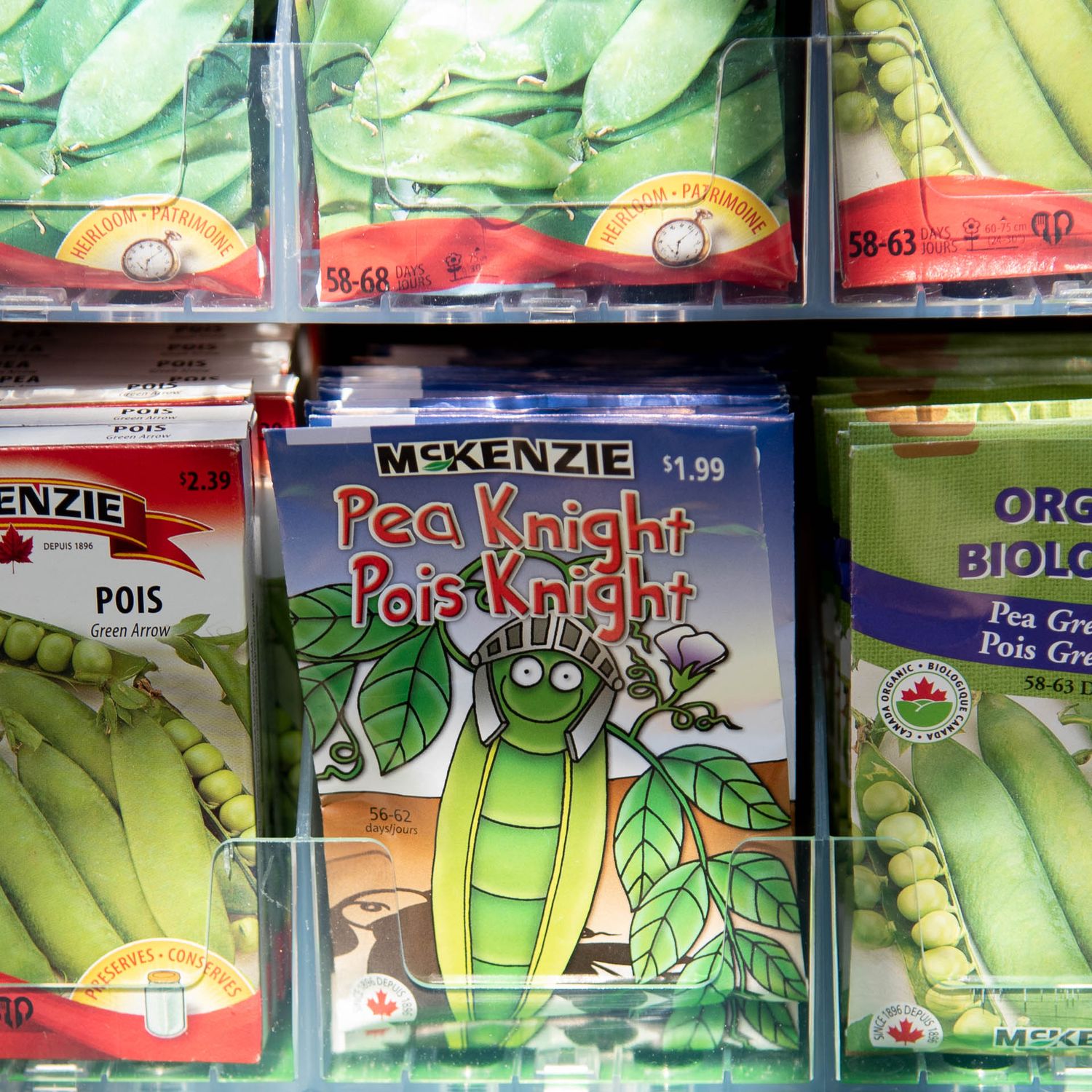 Retail seed packet display showing McKenzie Pea Knight Pole variety among rows of vegetable seed packages at Bradford Greenhouse in Barrie