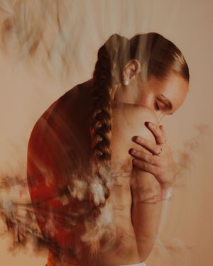 Multiple exposure artistic portrait showing ethereal double exposure effect with warm sepia tones and dreamy atmosphere.