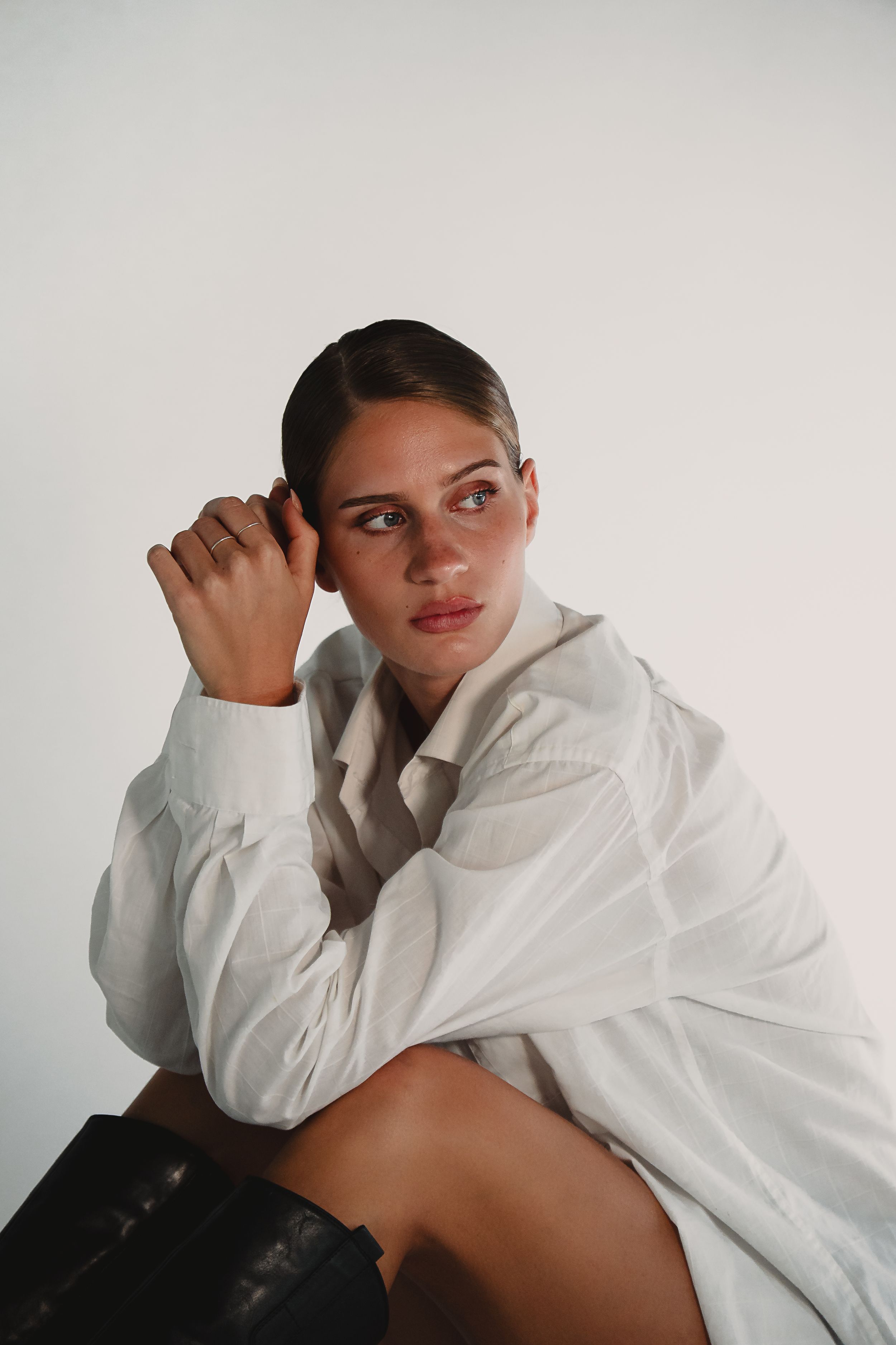 Artistic fashion poses in white button-down shirt against clean studio background.