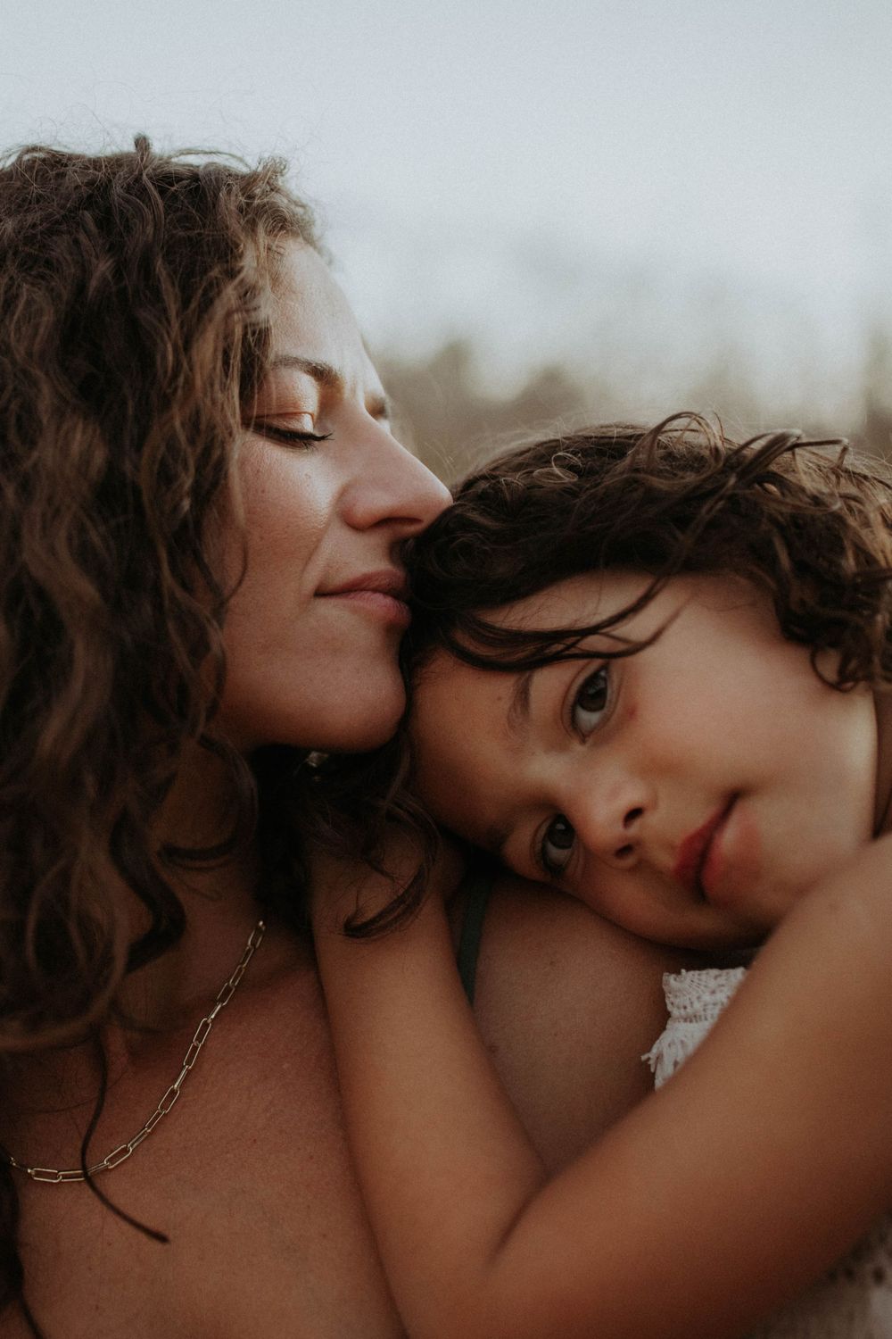 A tender moment captured in warm tones showing closeness and affection between parent and child.