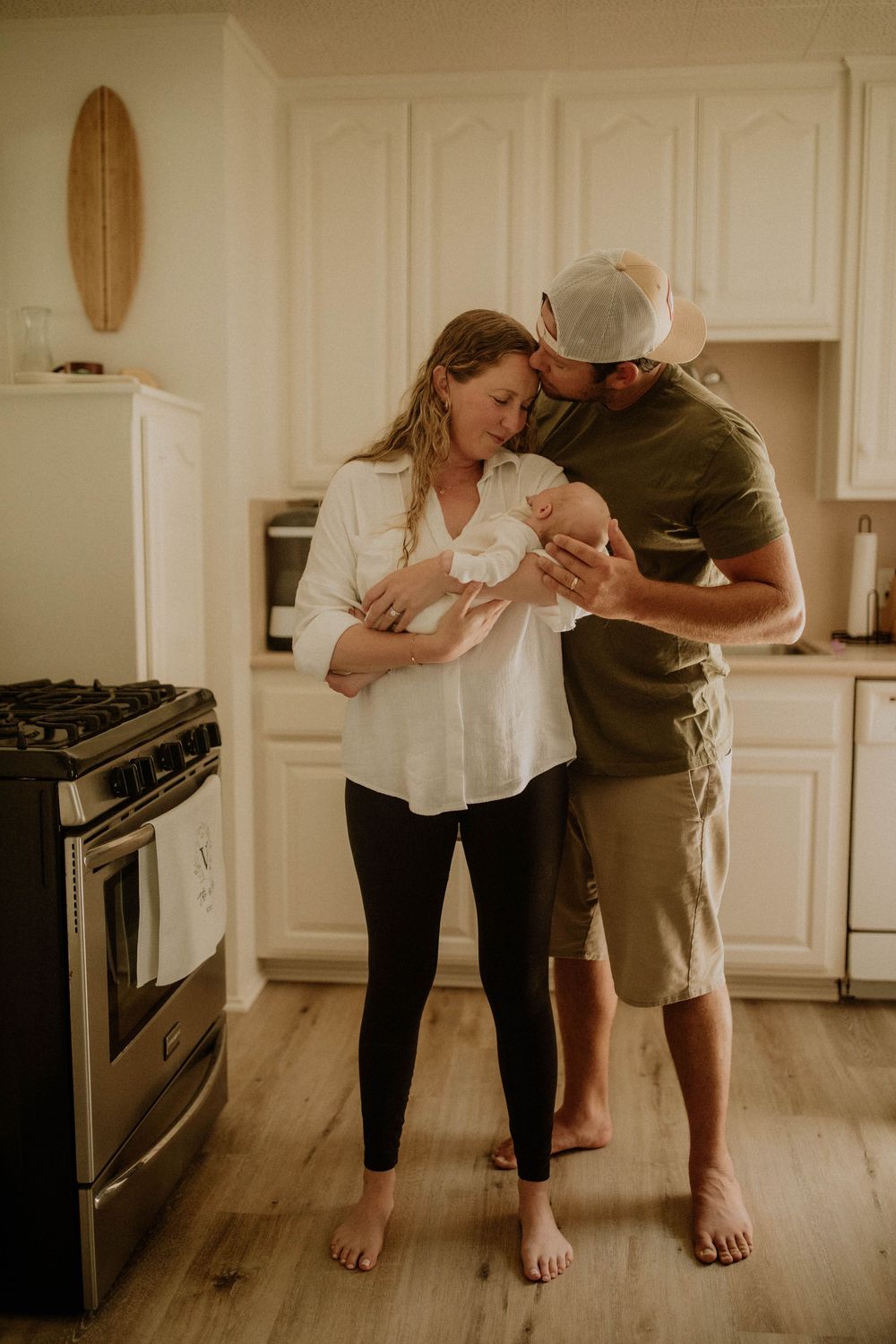 A couple stands together in a kitchen, sharing an intimate dance moment on hardwood floors.