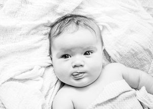 A creative collage of black and white close-up photographs showing an adorable baby's different facial expressions and moods.