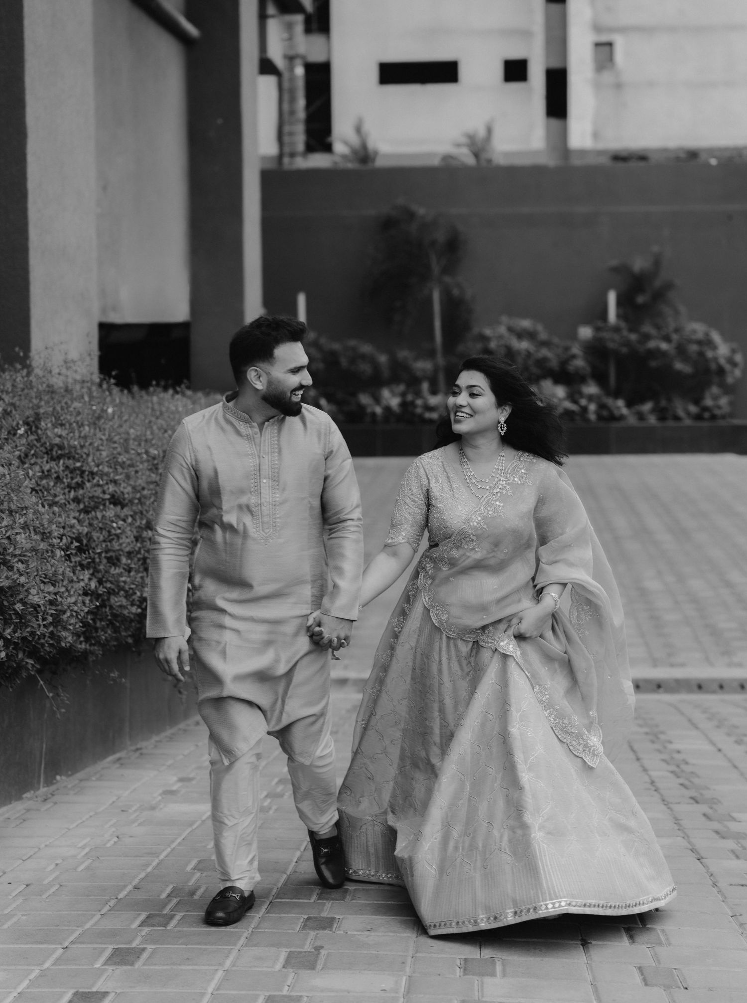 Intimate black and white portrait of a couple in traditional Indian attire sharing a tender moment together.
