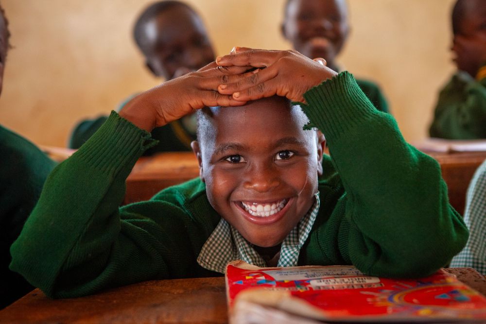 Students display joyful expressions while working at their desks.