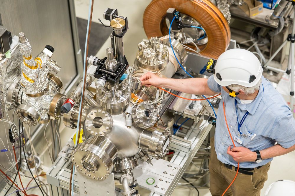 Laboratory scientist conducts research experiment using high-tech equipment and glass instruments in a scientific facility.