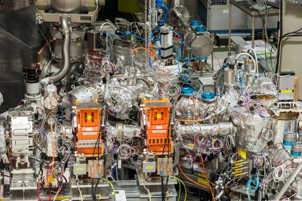 Complex industrial equipment and piping systems with gauges and controls in a manufacturing or laboratory setting.