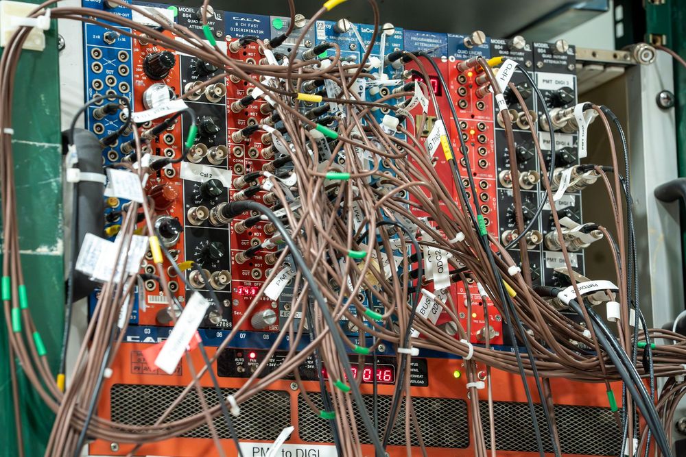 Complex wiring and electronic components inside a circuit control panel with red and blue cables interconnected.
