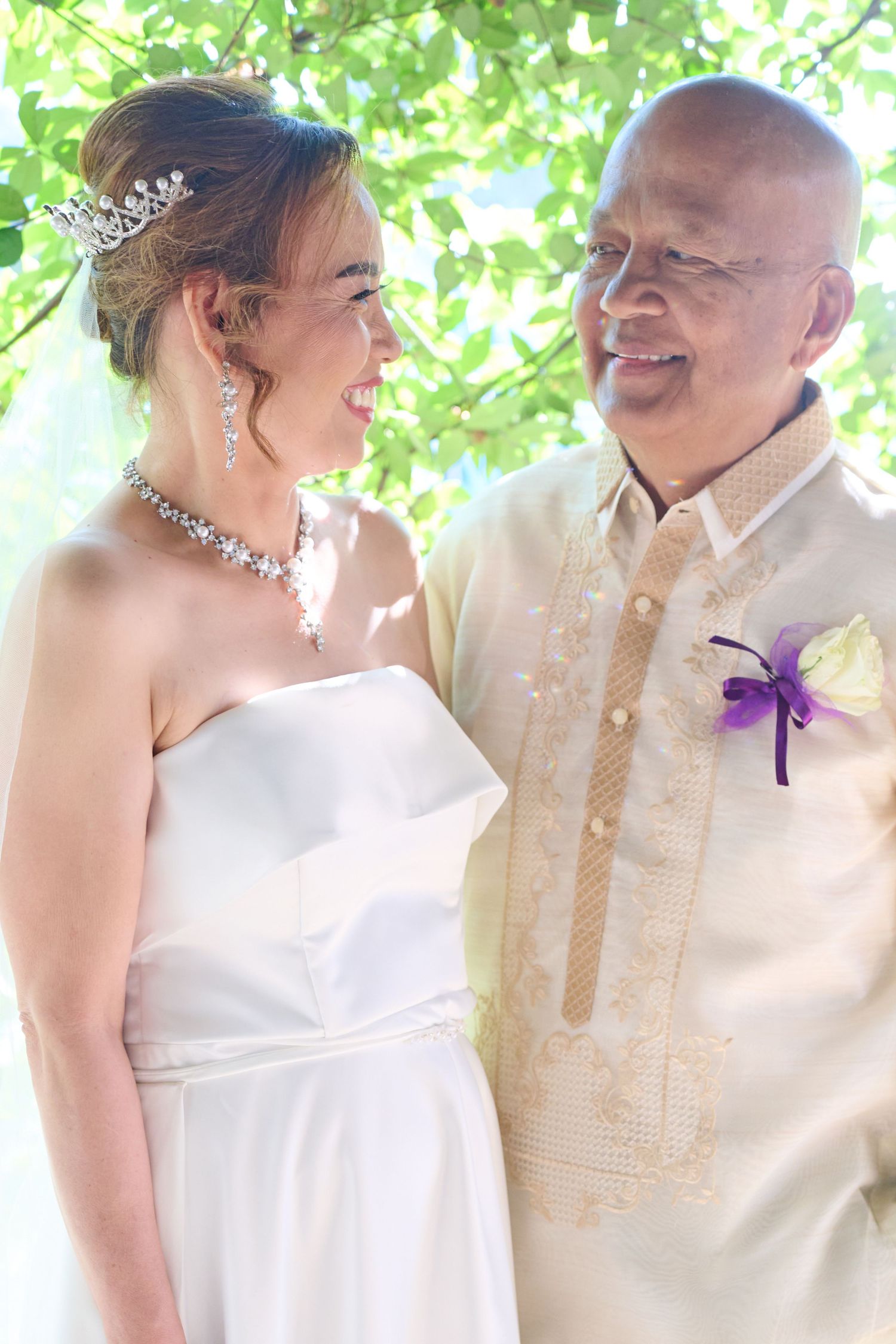 A happy couple poses for wedding photos in a church setting with white flowers and decor.