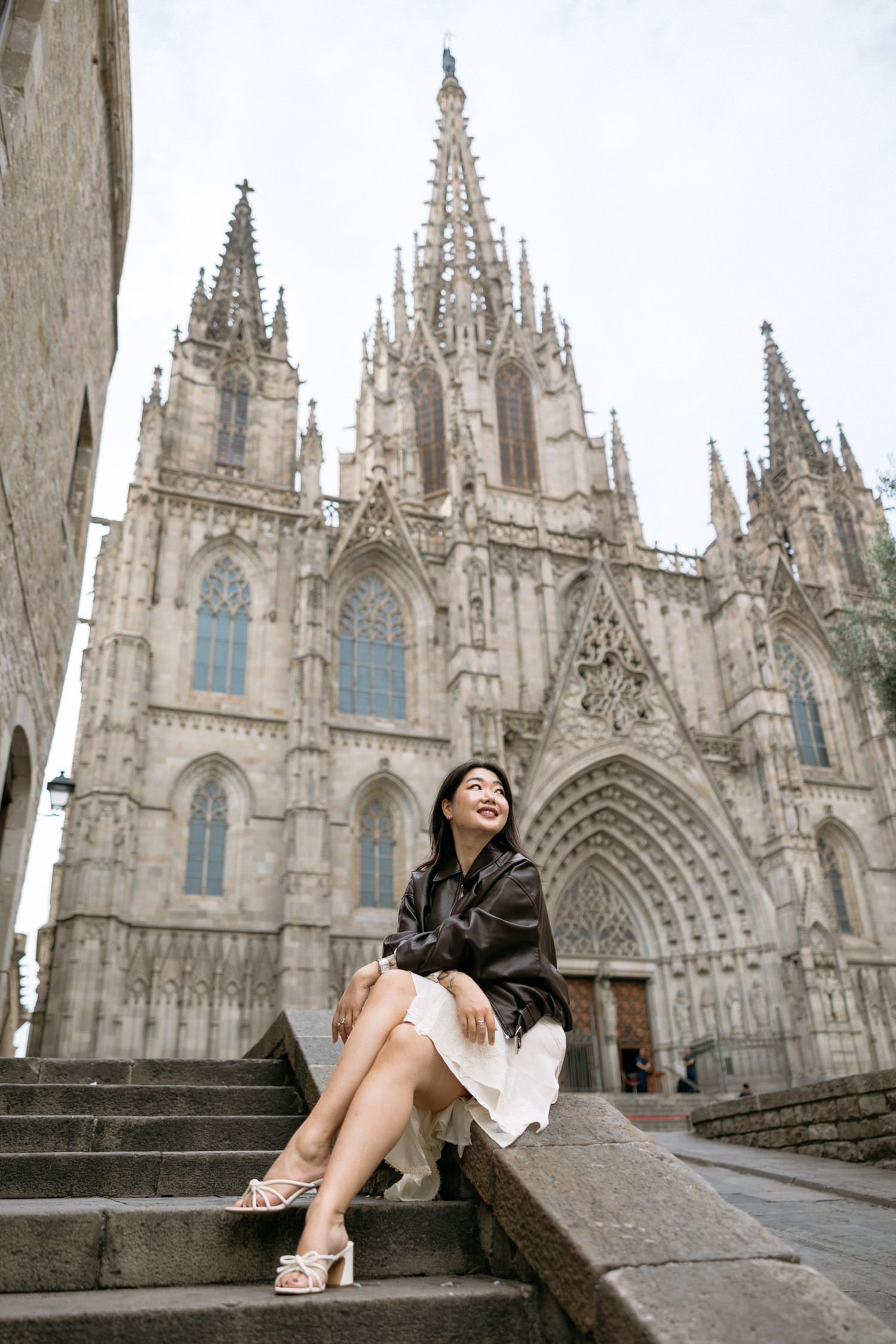 Gothic cathedral with ornate spires provides dramatic backdrop for artistic portrait.