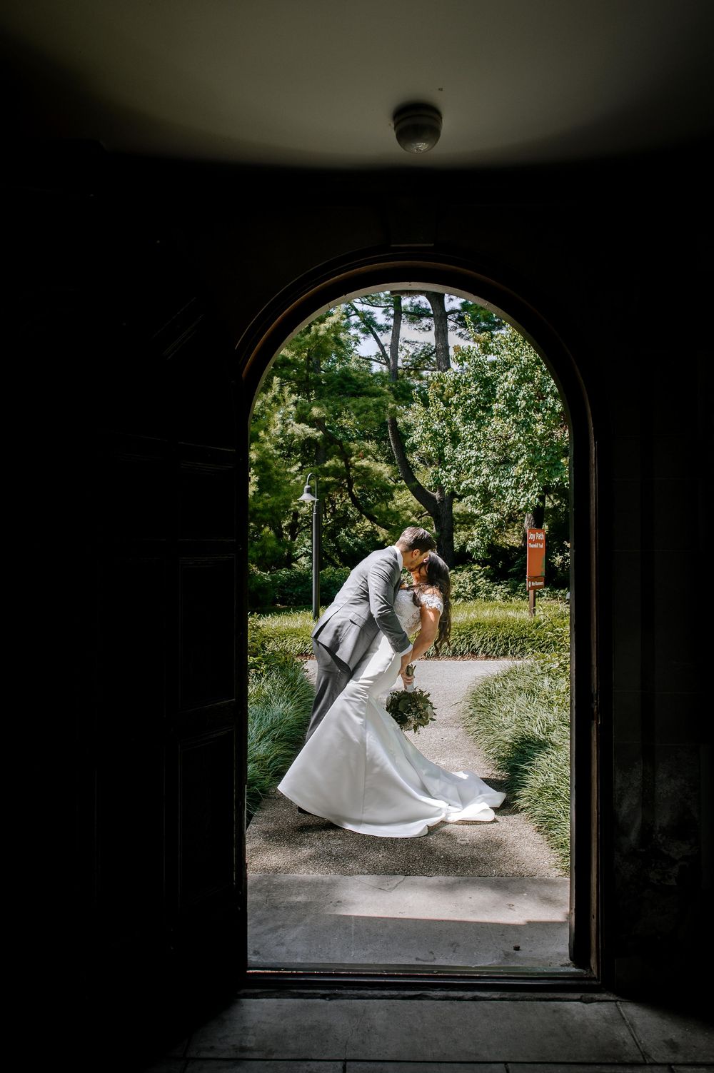 Wedding photoshoot through arched doorways showcasing elegant poses in natural lighting.