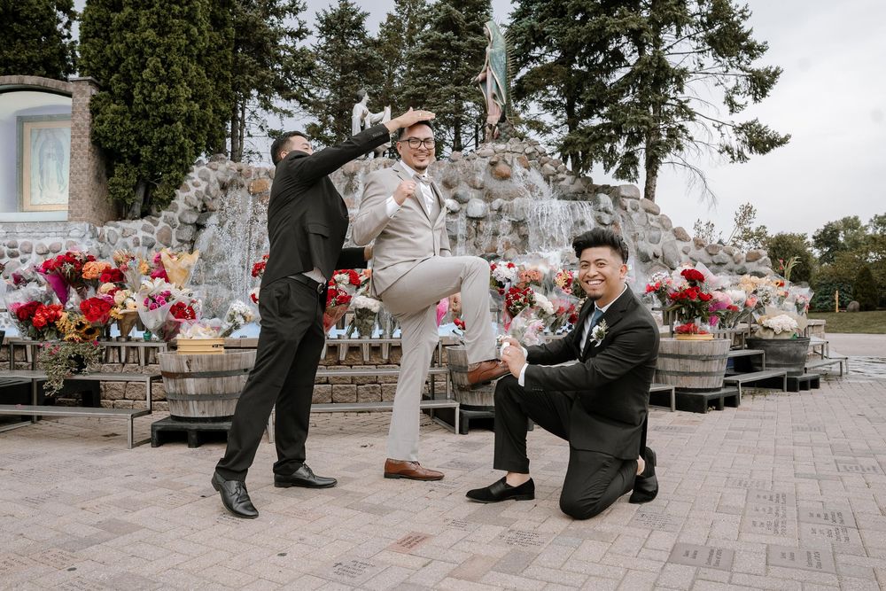 A wedding party performs coordinated dance moves in a sequence across a brick patio with floral arrangements visible.
