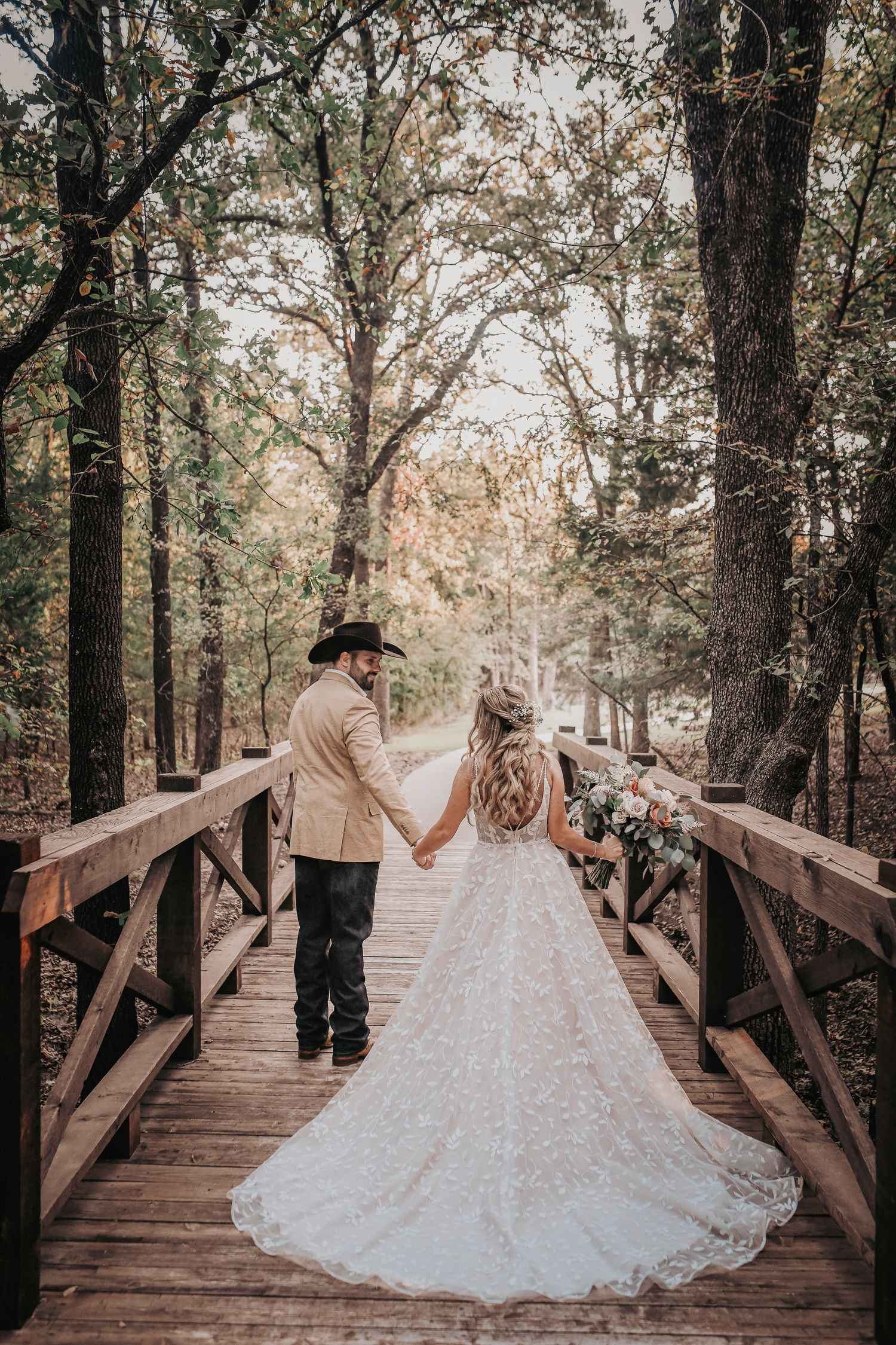 Groom kissing bride’s forehead on bridge – April Pinto Photography
