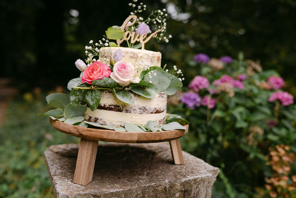 Close-up of floral wedding cake at Kasteel Aerwinkel garden reception.