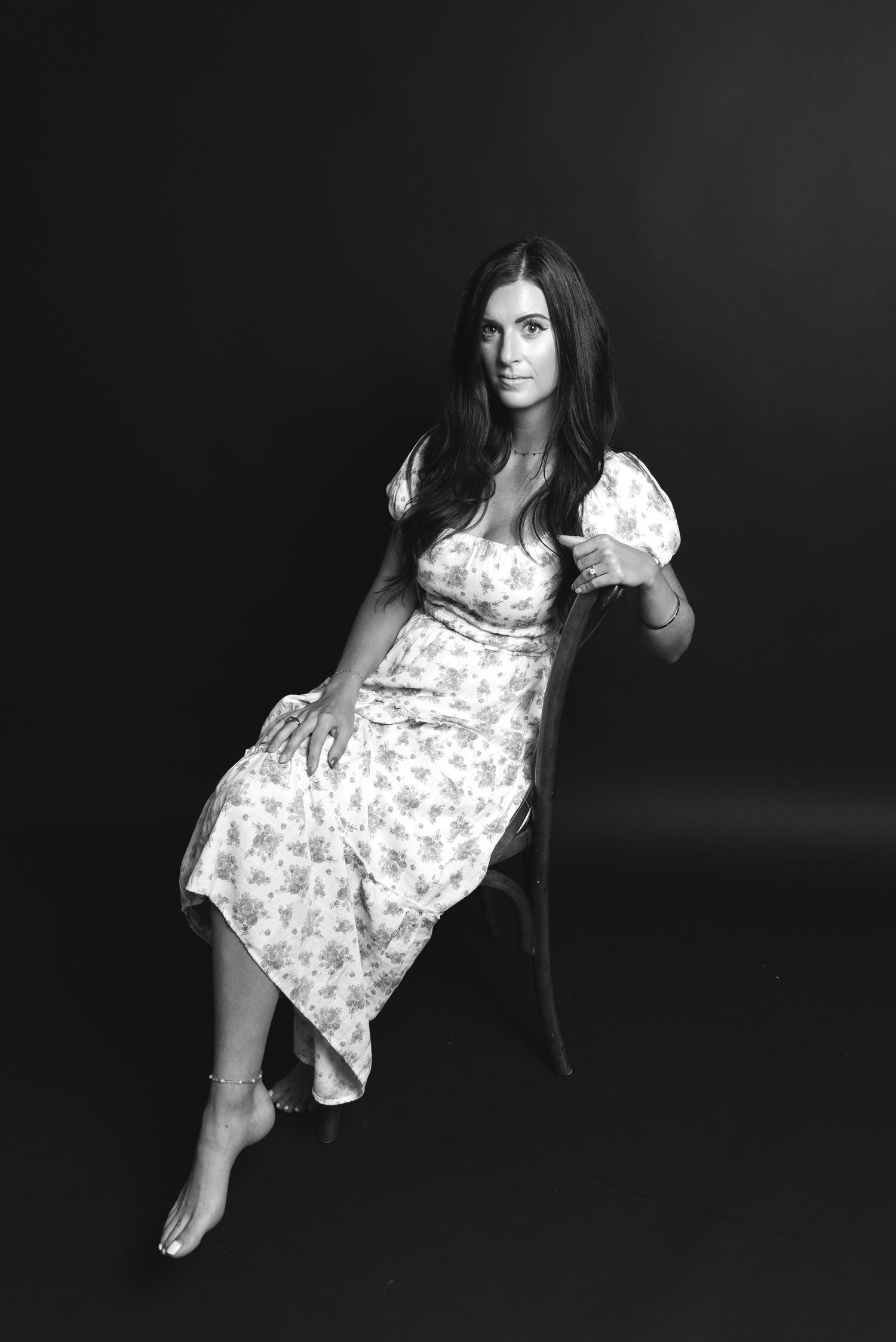 A series of black and white photos show a person in a floral dress posing with dramatic lighting and shadows.