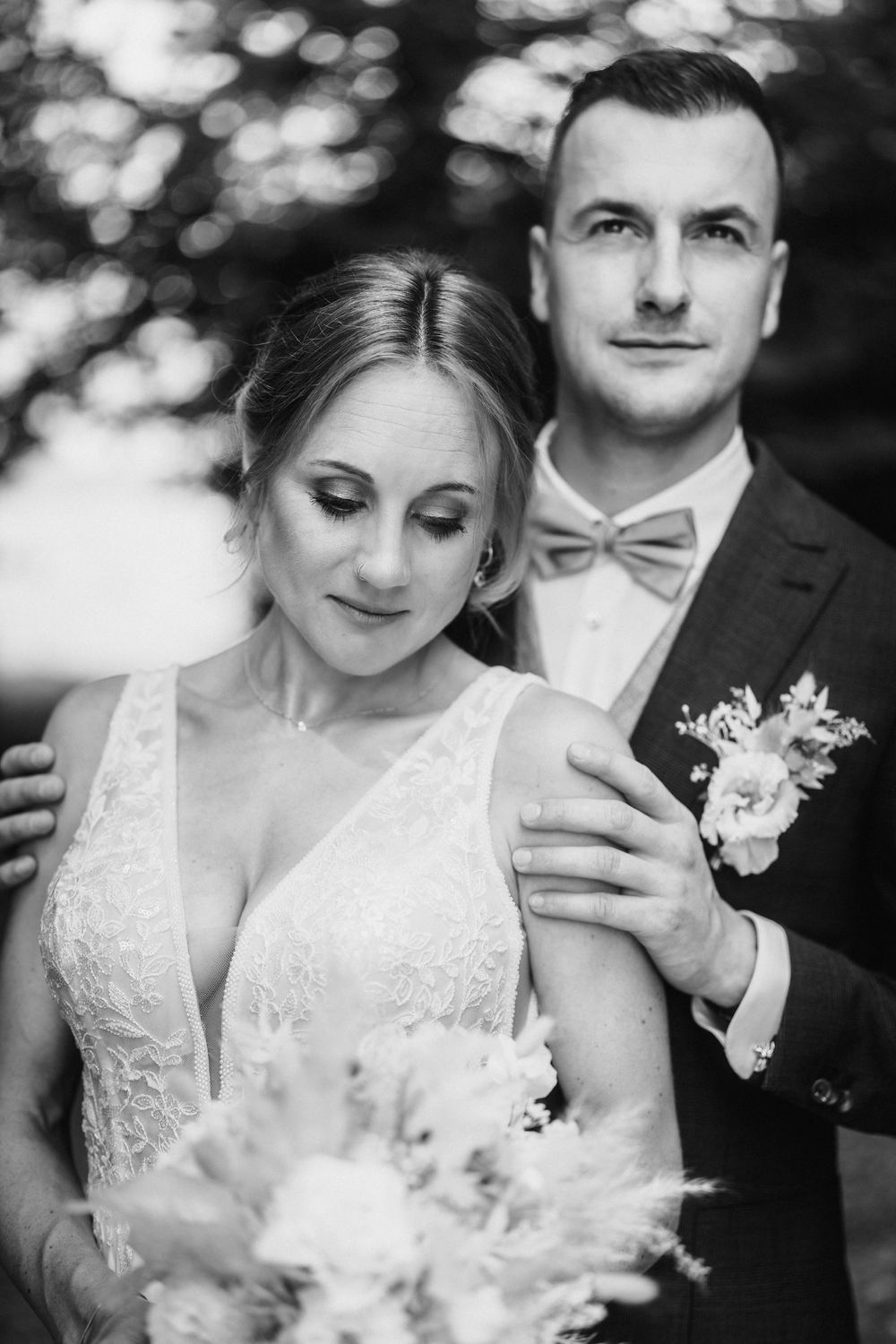A series of intimate black and white wedding portraits showing tender moments between a couple in formal attire.