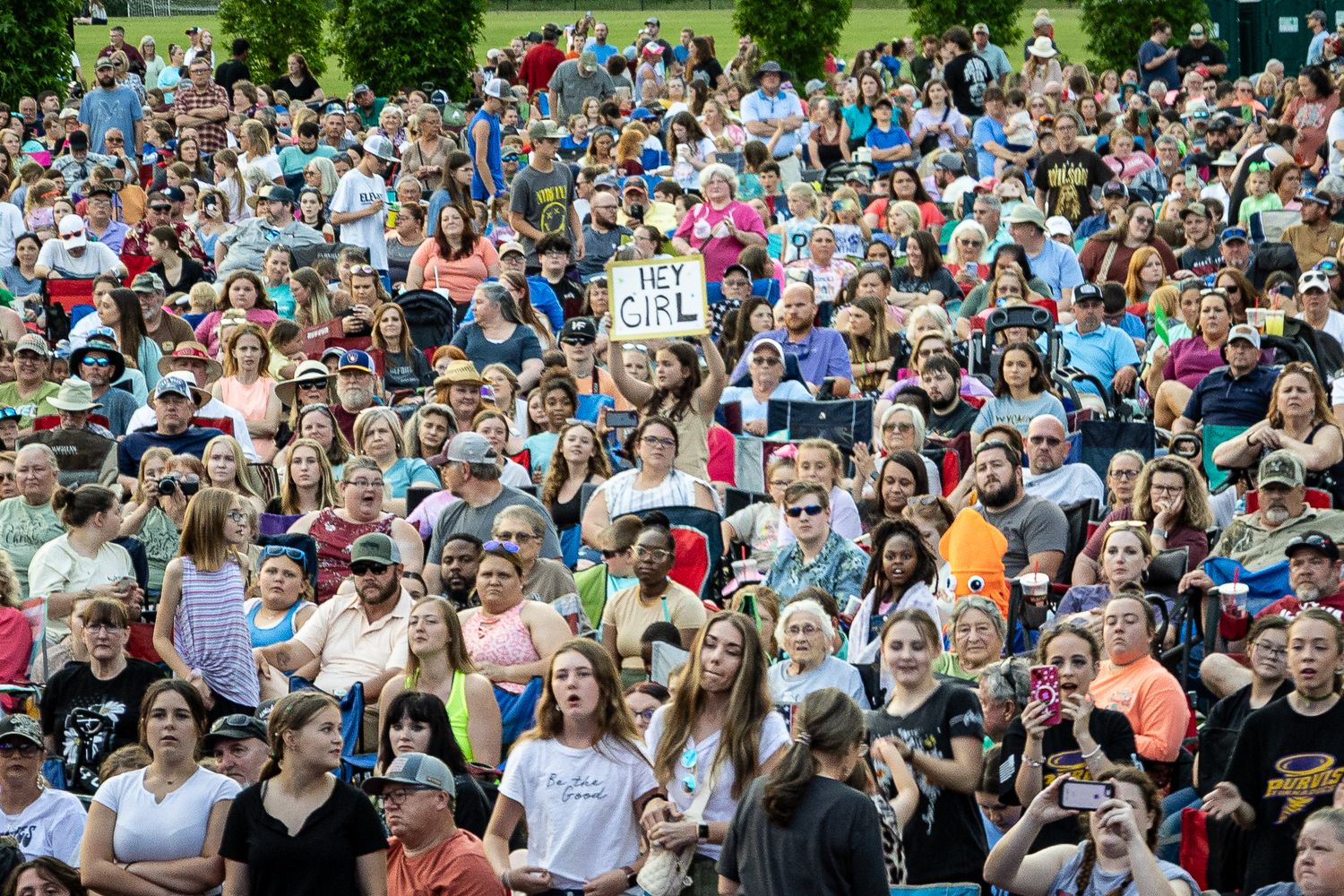 A large crowd of spectators gathered outdoors for a public event on a sunny day.
