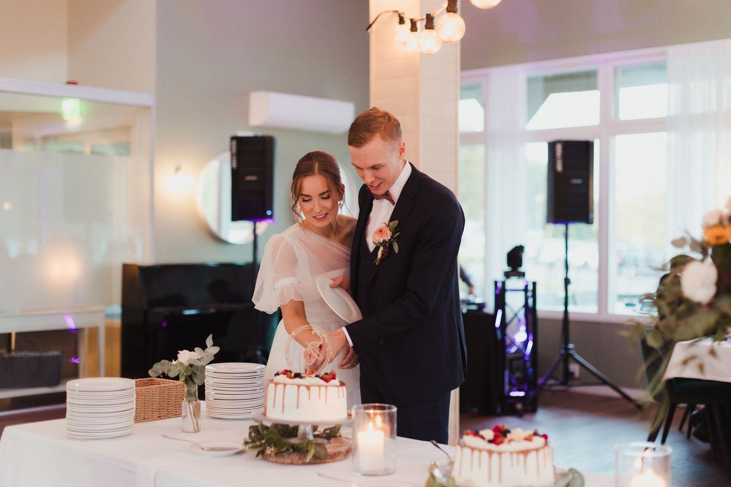 Wedding reception venue with couples dancing and mingling under warm lighting.