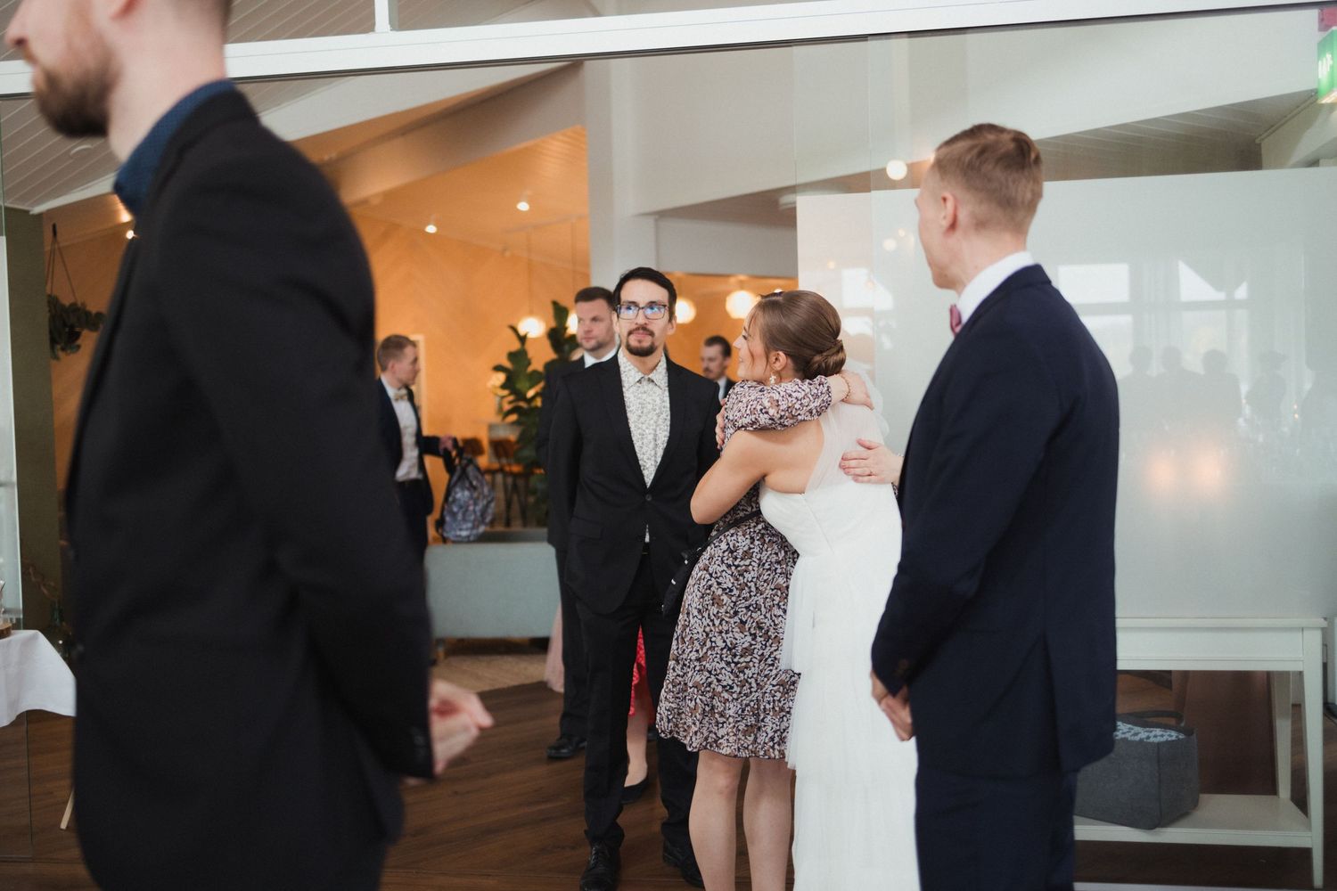Wedding guests enjoying conversation at an indoor reception venue.