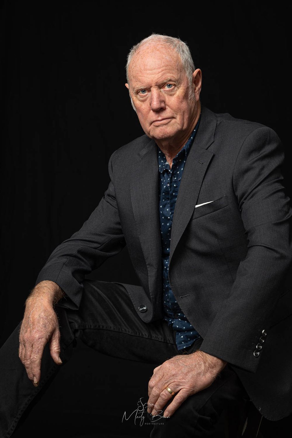 Corporate man in jacket sitting studio portrait