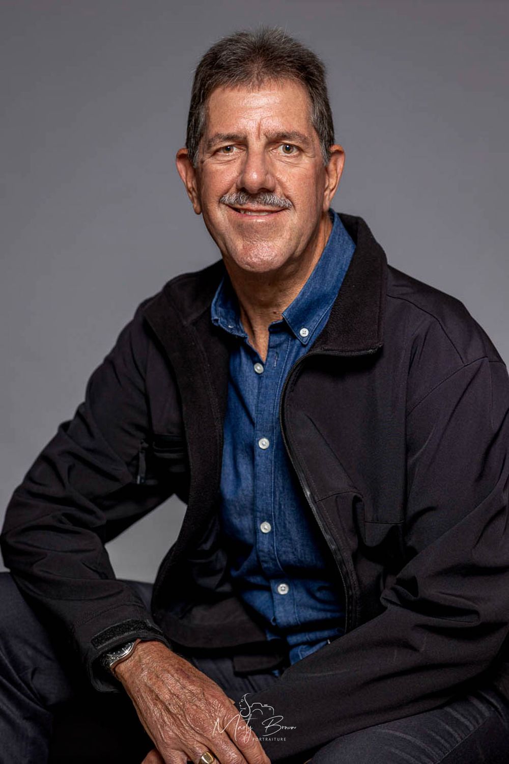 Corporate man in jacket sitting studio portrait