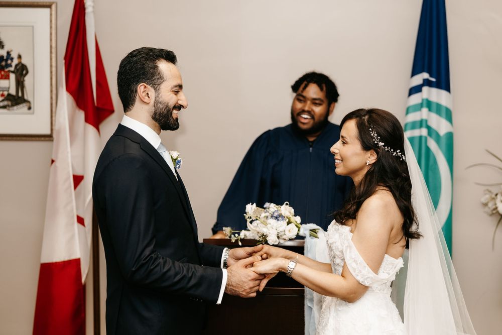 A sequence of candid moments between a couple exchanging wedding rings during an intimate ceremony with flags in background.