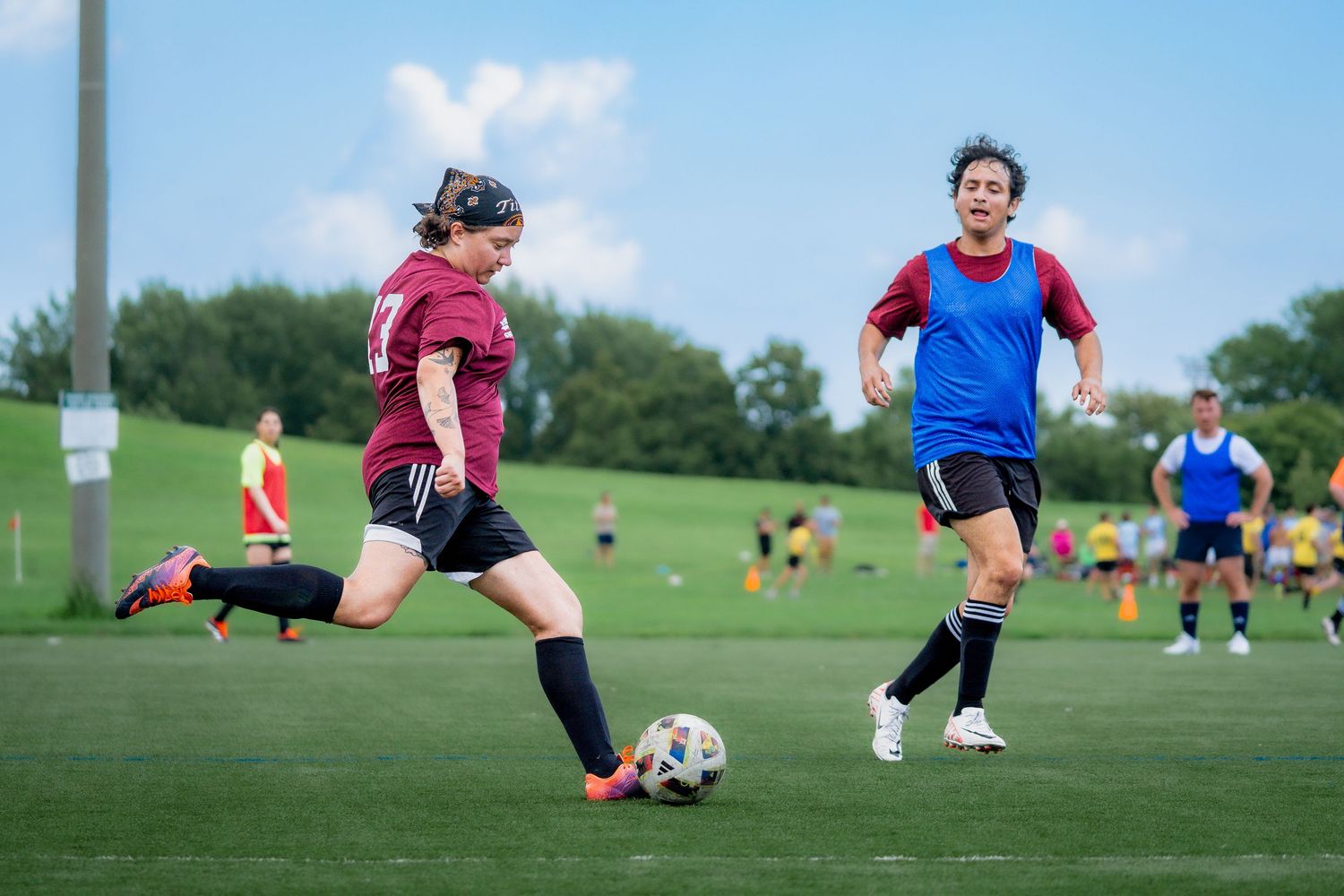 A soccer athlete winds up to kick the ball downfield in a park in Chicago