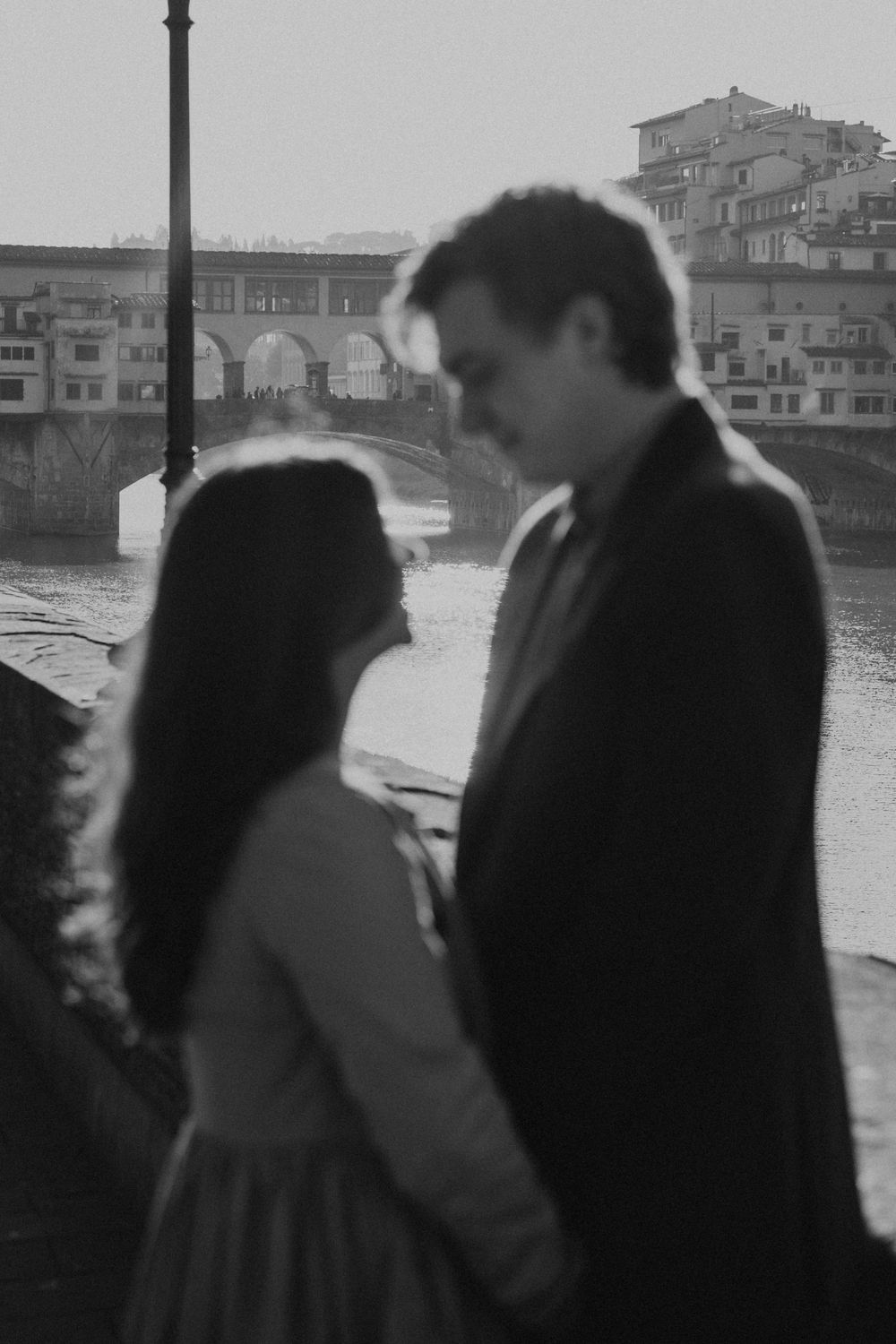Silhouettes of people standing against a Florence cityscape in black and white.