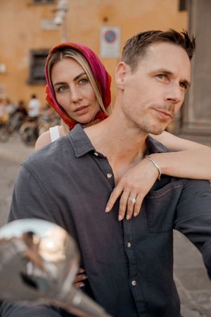 A couple sharing intimate moments in warm evening light against an urban backdrop.