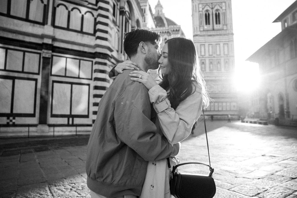 Romantic couple photography session against historic Italian architecture in the morning at Piazza del Duomo in Florence, Italy.