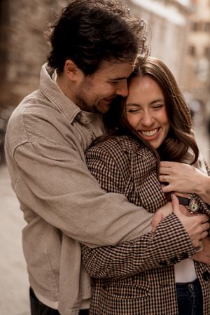 A couple shares a tender embrace and joyful laughter in a warm sepia-toned photo sequence.