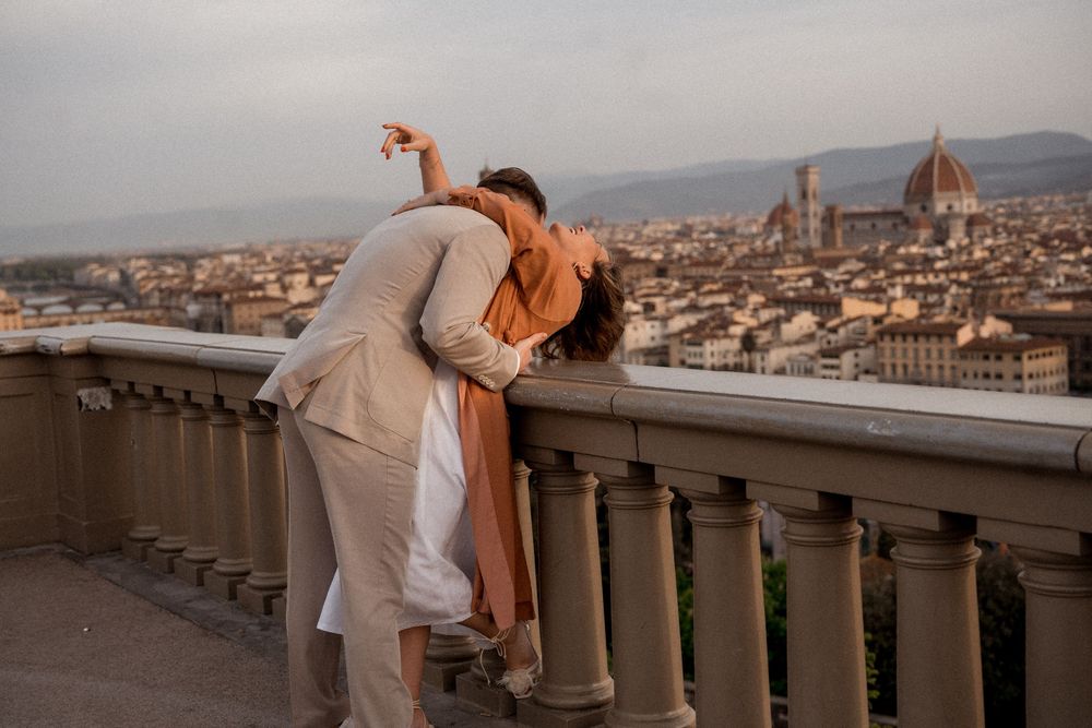 Romantic couple shares a dramatic dip pose overlooking Florence cityscape at sunset.