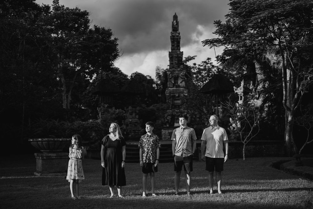 Black and white photo of family members walking together in a park setting.