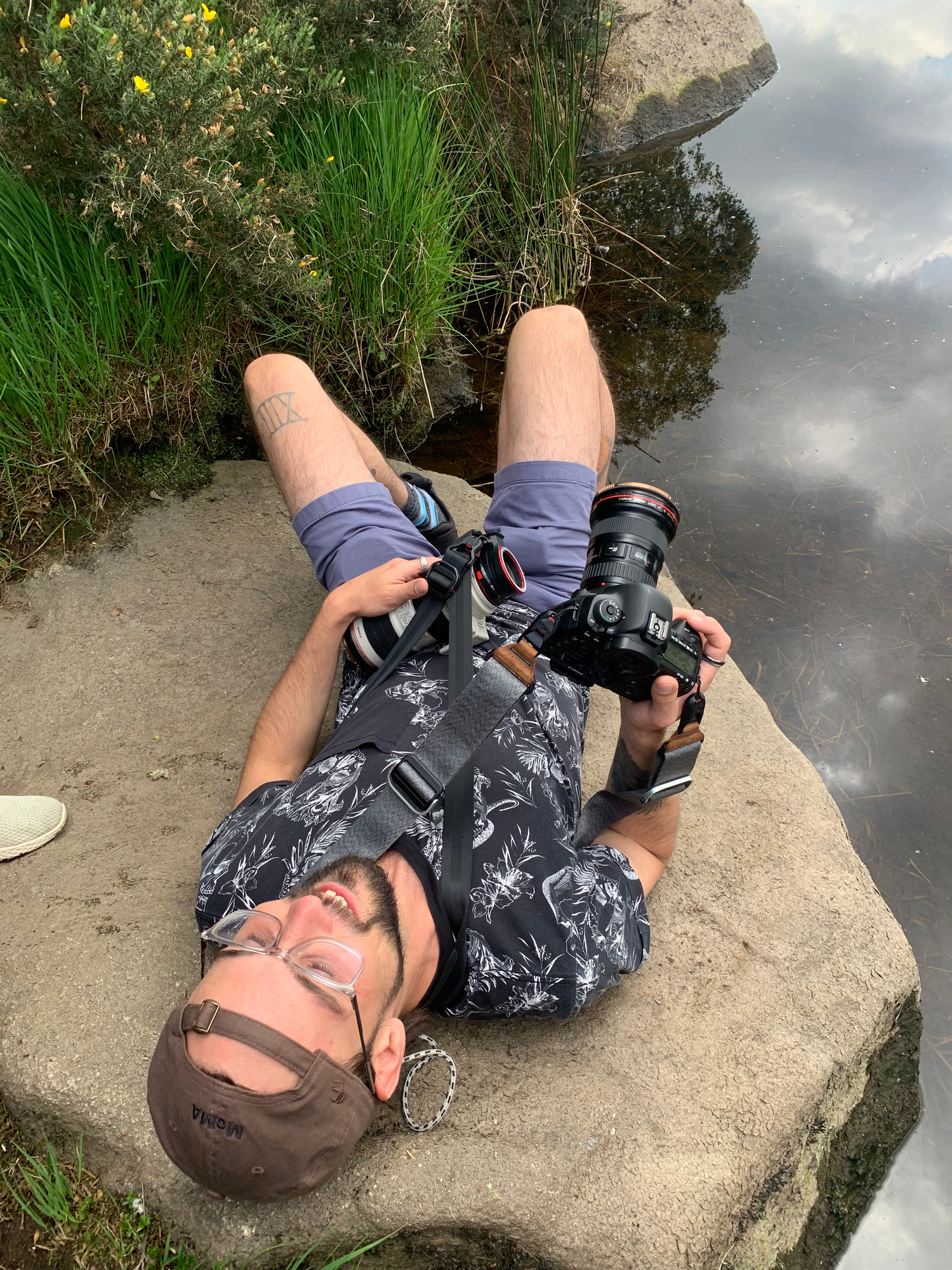 Close-up shots of camera equipment resting on a stone surface outdoors.