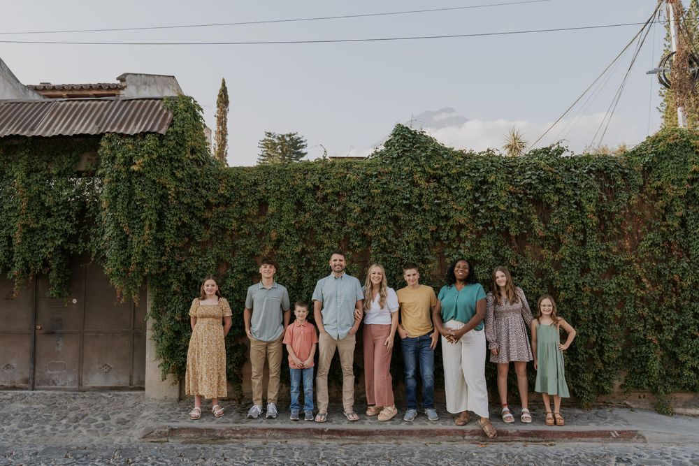 A series of coordinated family group photo sessions with various poses and outfits in an outdoor garden setting.