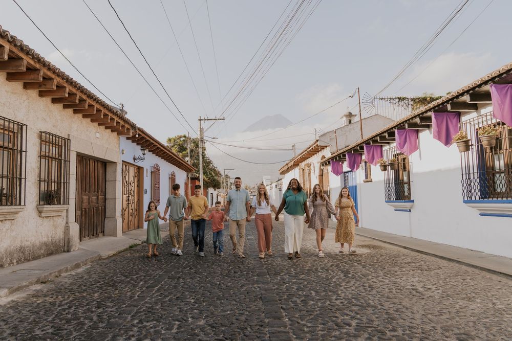 A cobblestone street lined with colorful colonial buildings and banners strung overhead in Antigua, Guatemala.