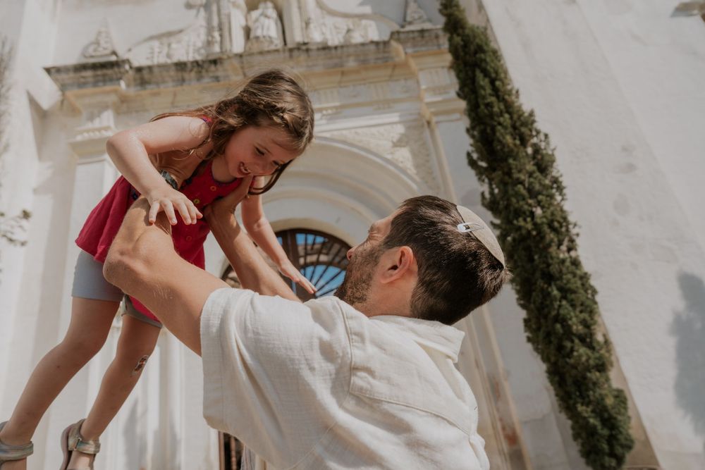 A couple shares an intimate moment during their wedding ceremony under an ornate architectural backdrop.
