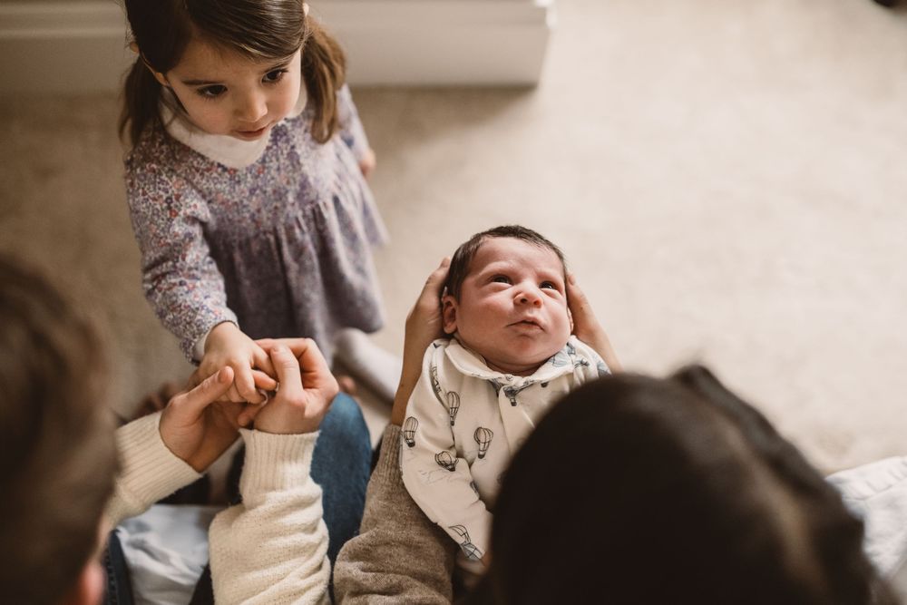 A family moment shared by parents, newborn baby and toddler.
