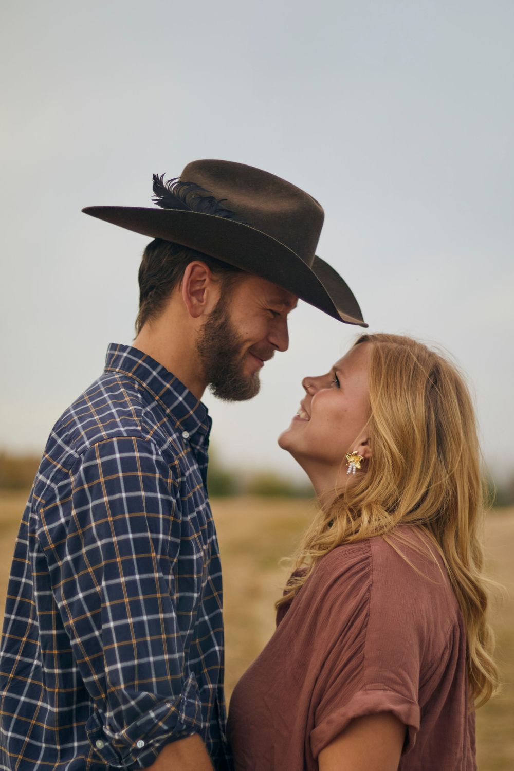 Couple engagement photoshoot. Man and woman looking into each others eyes and smiling