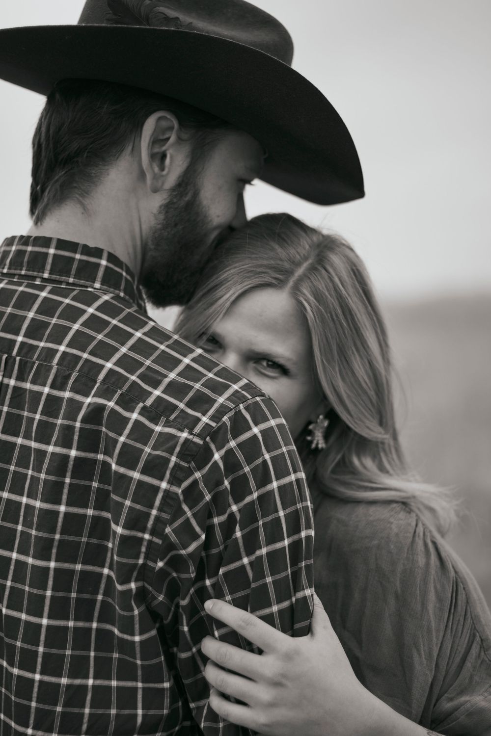 Couple photoshoot outdoors in black and white with the woman looking into the camera