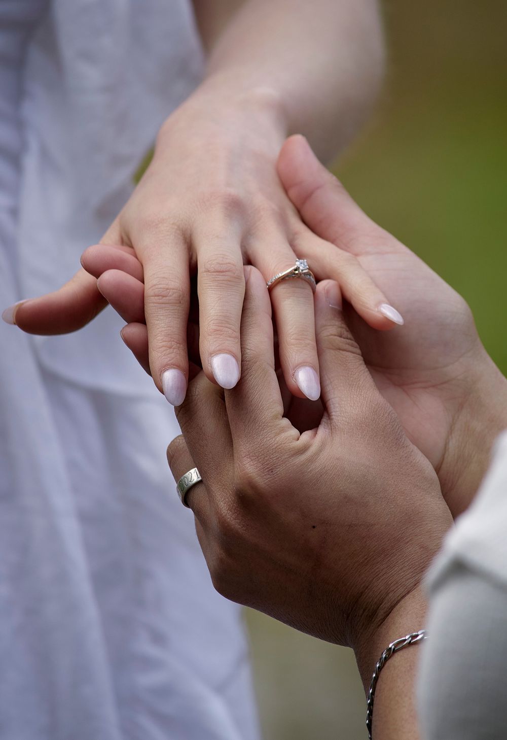 Engagement photo of man putting the ring on a woman's finger