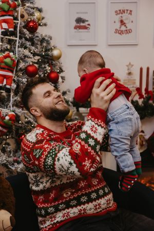 A heartwarming holiday moment with a Christmas sweater and decorated tree.