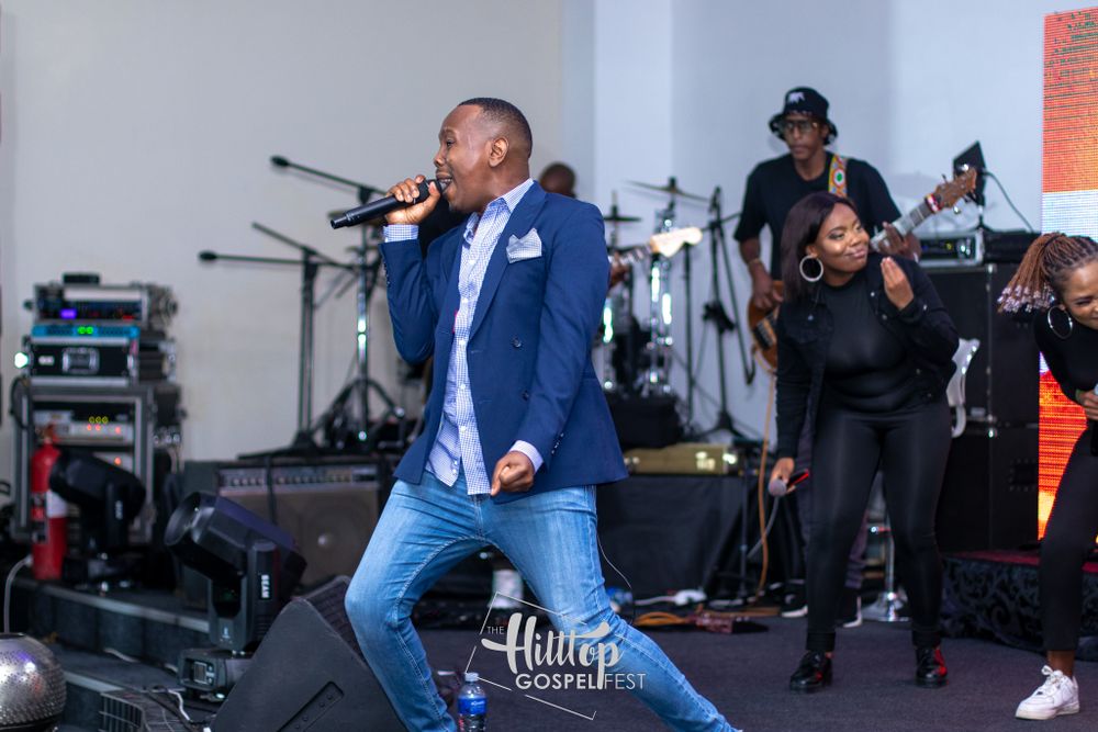 A dynamic stage performance featuring musicians and backup singers with professional lighting setup.