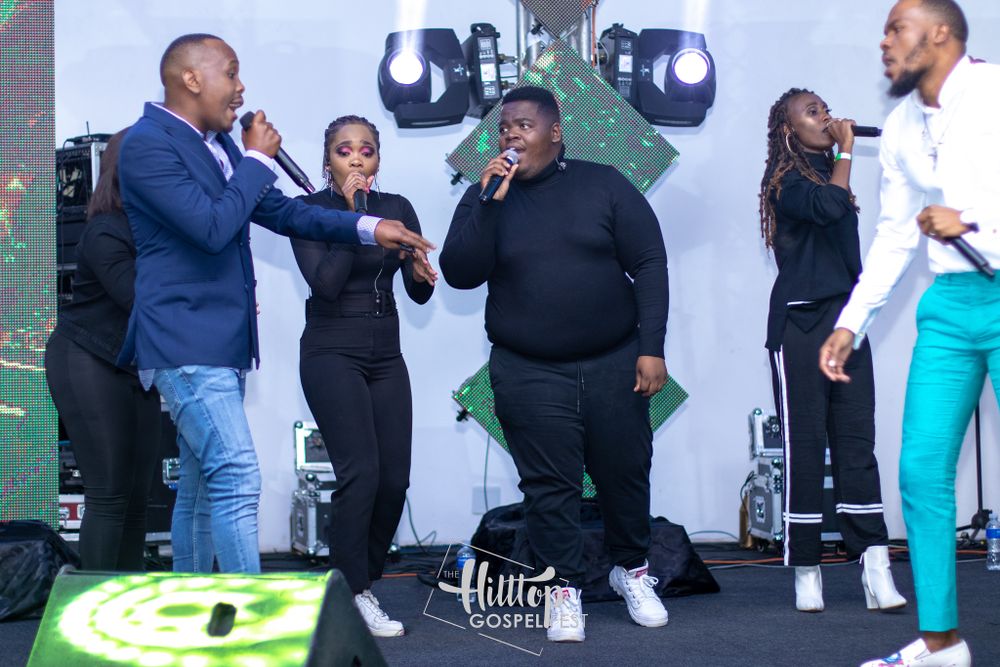Performers interact energetically on stage during a live musical performance.