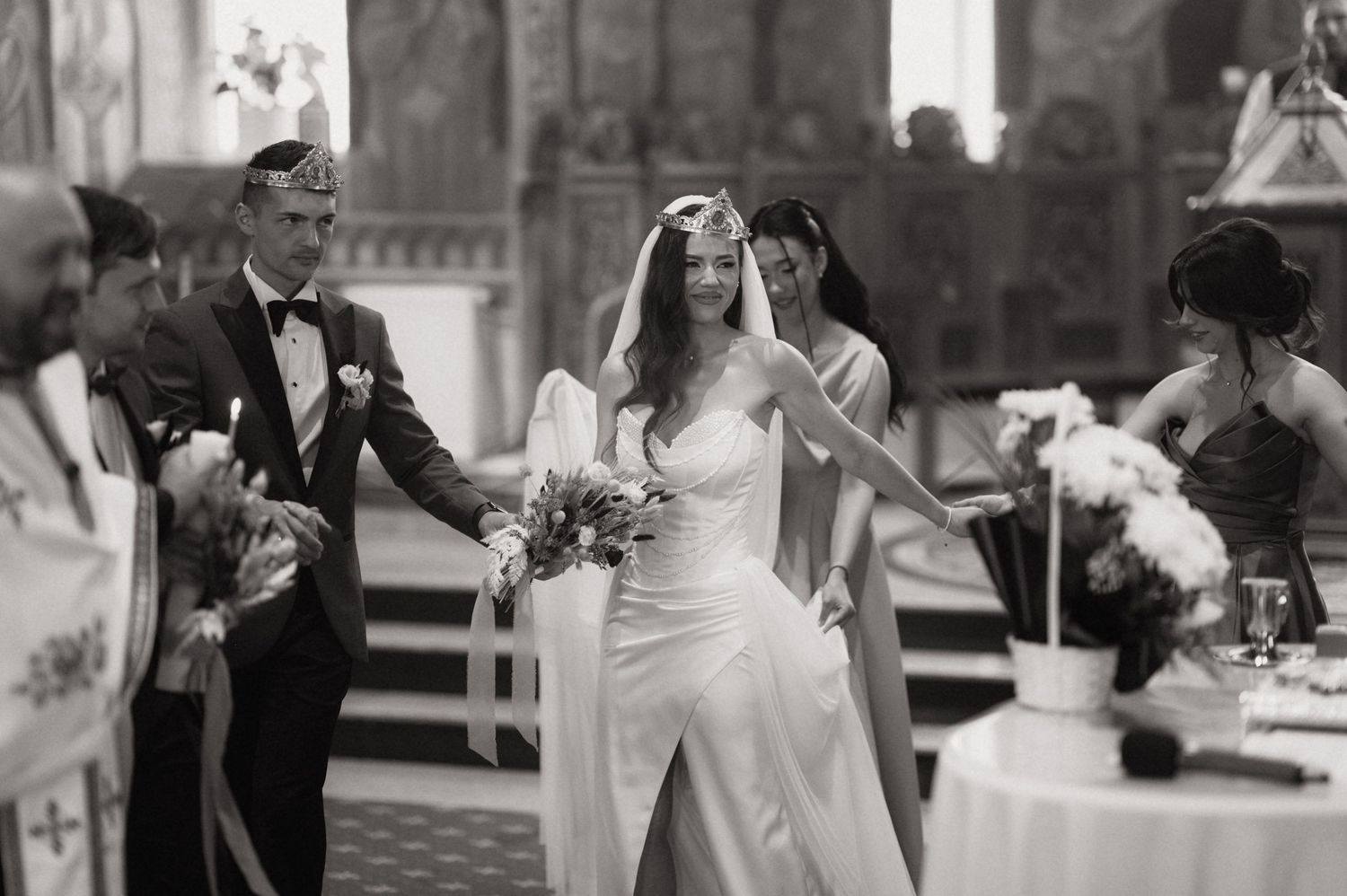 Black and white photo of a bride and groom walking down the aisle during a church wedding ceremony.