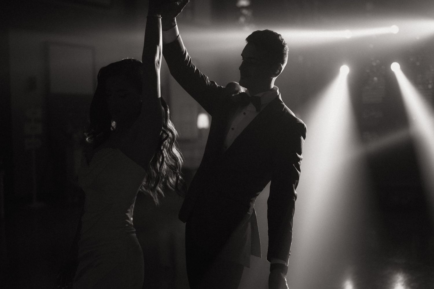 Black and white photo of a couple sharing a romantic first dance at their wedding reception.
