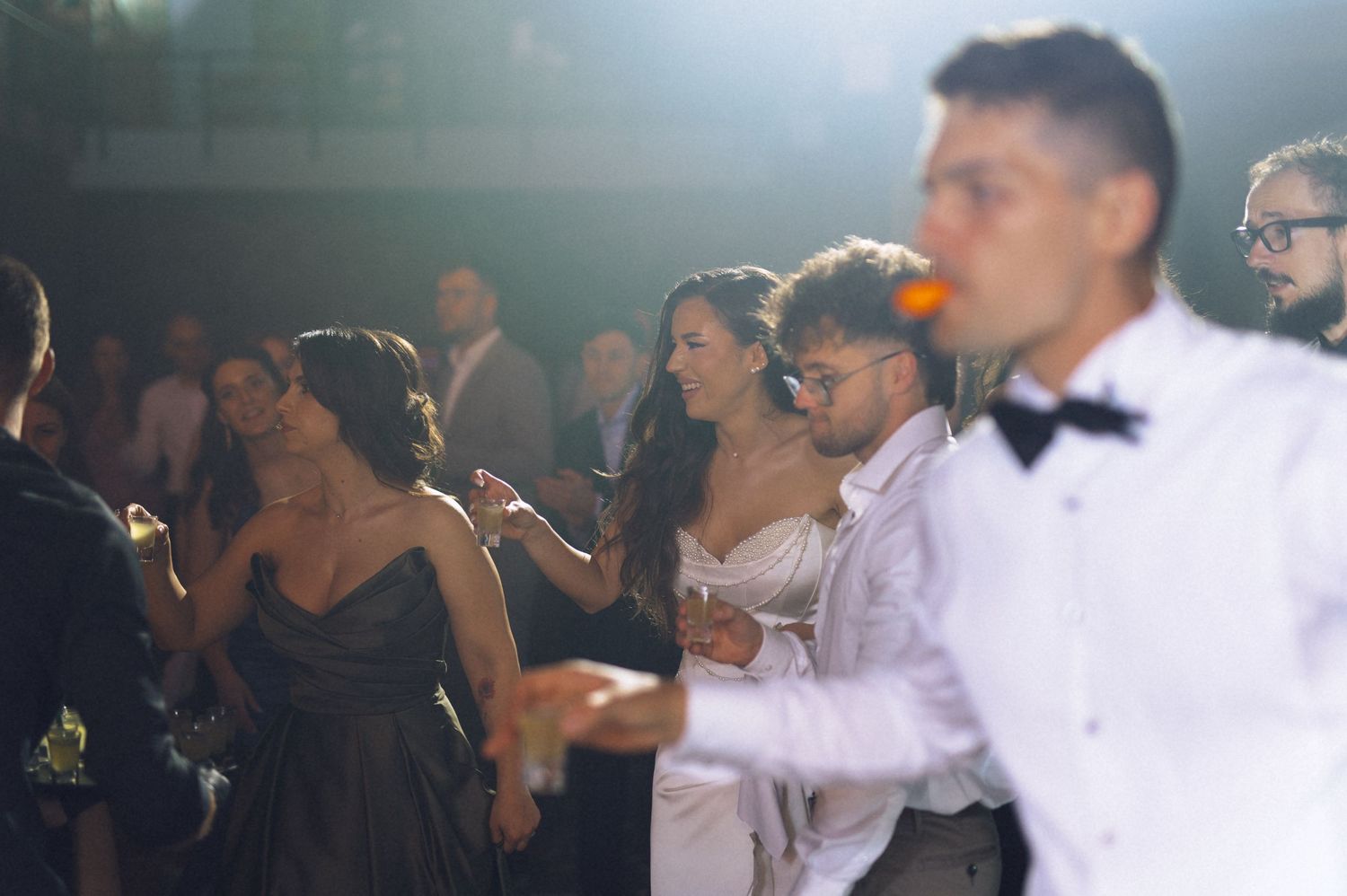 Guests dancing and celebrating at an elegant outdoor wedding reception at night.